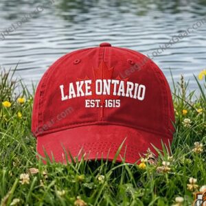 Black cap displayed beside lakeside water with front graphic visible