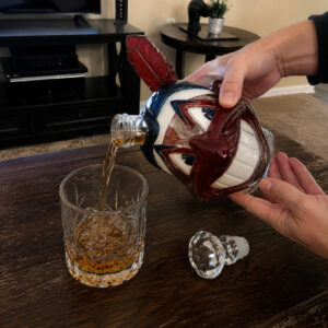 Lets Go Tribe 125th Anniversary Chief Wahoo Whiskey Decanter 2026 - side view highlighting the red feather