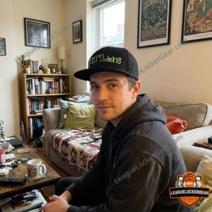 Man wearing the black ATLiens snapback at home
